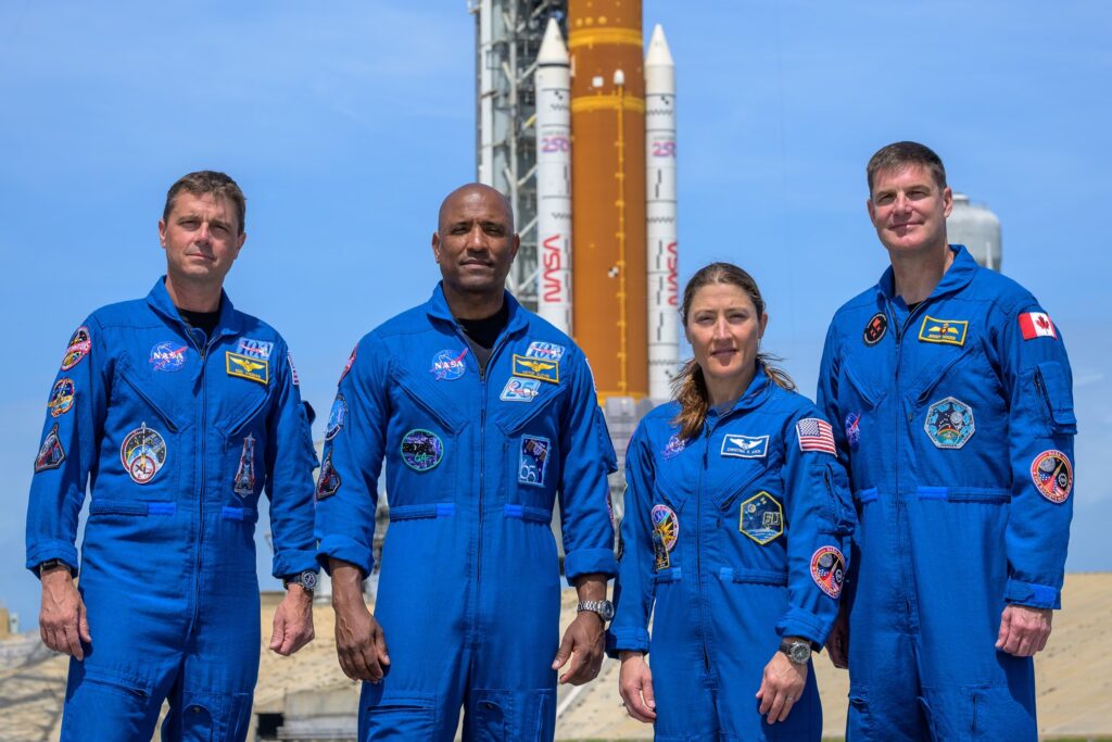 Posádka Artemis II stojí pri rakete SLS a lodi Orion pred štartom misie k Mesiacu